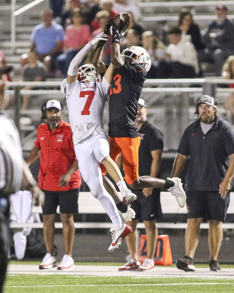 Plainfield East's Markeith Taylor (13) makes a sideline catch over Yorkville's Daniel Kraus (7)  during football game between Yorkville at Plainfield East Friday, Sept 19, 2025 in Plainfield.