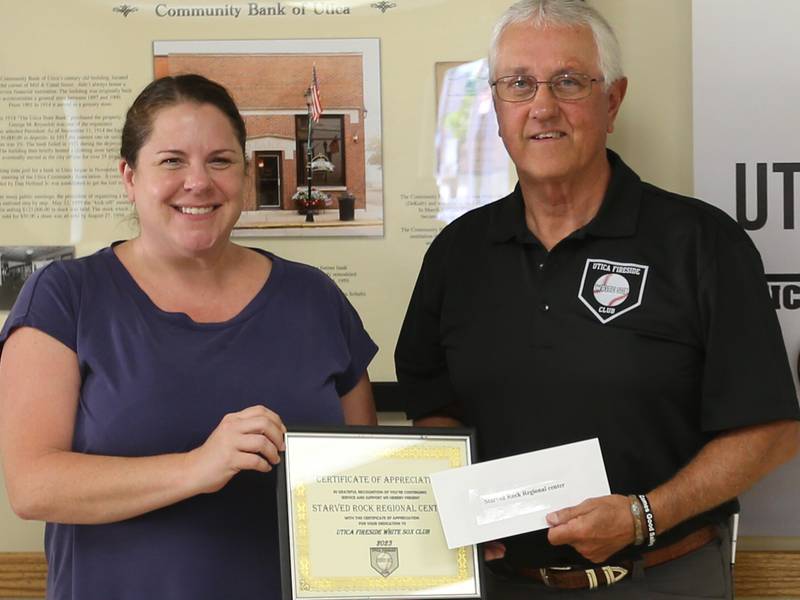 Tracy Beattie president of Starved Rock Regional Center is handed a donation check from Utica Fireside White Sox Club member Randy Tuftie during the 14th annual Utica Fireside White Sox Club donation presentation on Tuesday, Aug. 15, 2023 at the Utica Township Community Building.