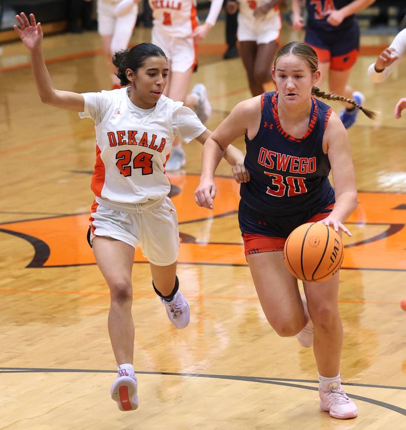Oswego's Peyton Johnson pushes the ball ahead of DeKalb's Nazeria Dean during their game Monday, Jan. 5, 2026, at DeKalb High School.