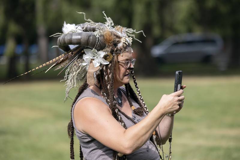 Donned up as a mythical, forest creature, Liz Mathews of Sterling snaps some video Saturday, Sept. 21, 2024, while watching the festivities at Lowell Park.
