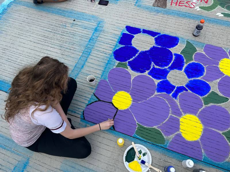 CeCe Wendt, of Fulton, paints purple flowers in her square at Paint the Town in Morrison on Saturday.