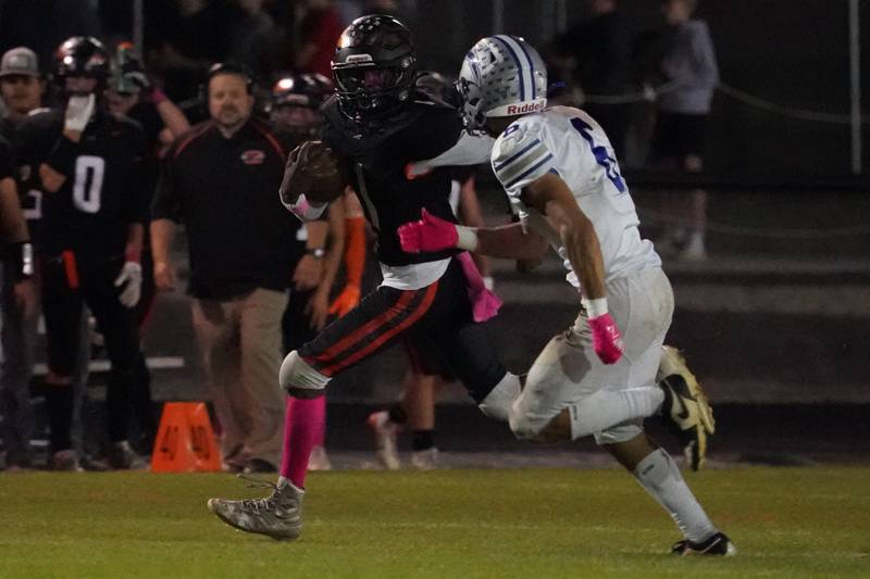 Sandwich's Simeion Harris (1) runs after the catch against Woodstock's Matthew Cress (6) during a football game at Sandwich High School on Friday, Oct. 11, 2024.