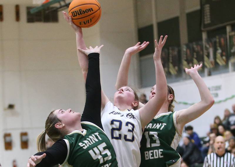Marquette's Kelsey Cuchra lets go of a shot between St. Bede's Savannah Bray and Ashlyn Ehm during the Class 1A Regional semifinal game on Tuesday, Feb. 18, 2025 at St. Bede Academy.