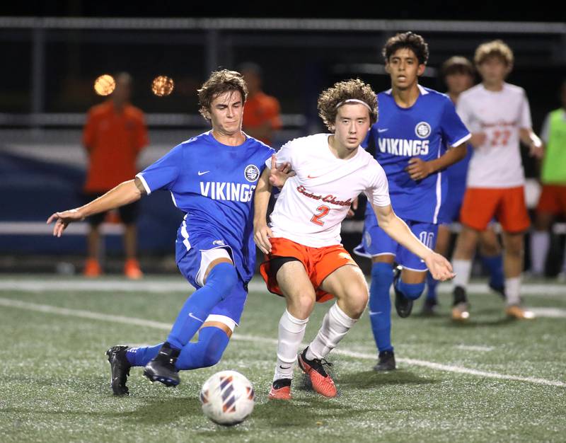 Geneva’s Evan Swierczewski and St. Charles East’s Brandon Garland go after the ball during a game at Geneva on Tuesday, Oct. 3, 2023.
