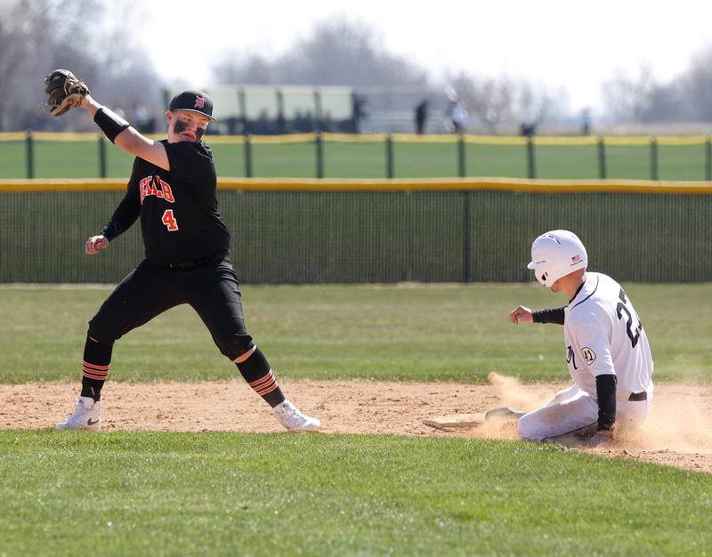 Kaneland's Thomas Thill advances on a wild pitch as DeKalb's Breydon Martin takes the throw during their game Saturday, April 12, 2025, at Kaneland High School in Maple Park.