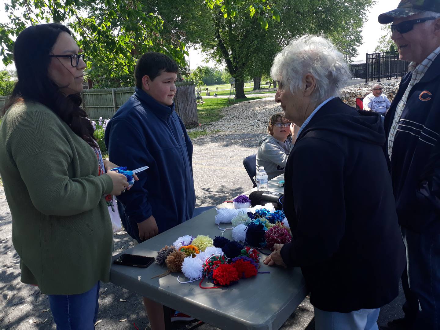 Waltham fifth grader Liam Pearce and his mother Nicki talk to customers Saturday, May 20, 2023, during Lemonade Day as his business partner Alex Green looks on. Together they operated A & L Pom Poms.