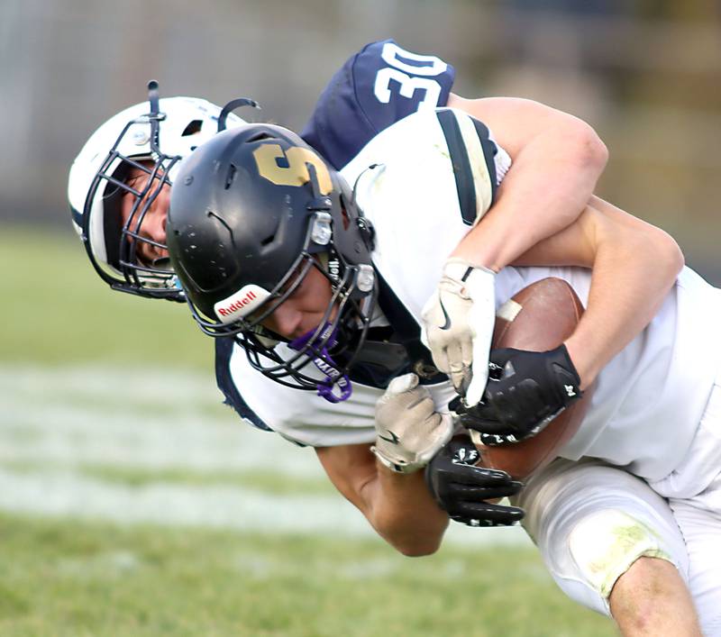 Cary-Grove’s Landon Moore wraps up Benjamin Anderson of Sycamore in IHSA football Class 5A first-round playoff action at Al Bohrer Field on the campus of Cary-Grove High School in Cary on Saturday, November 1, 2025.