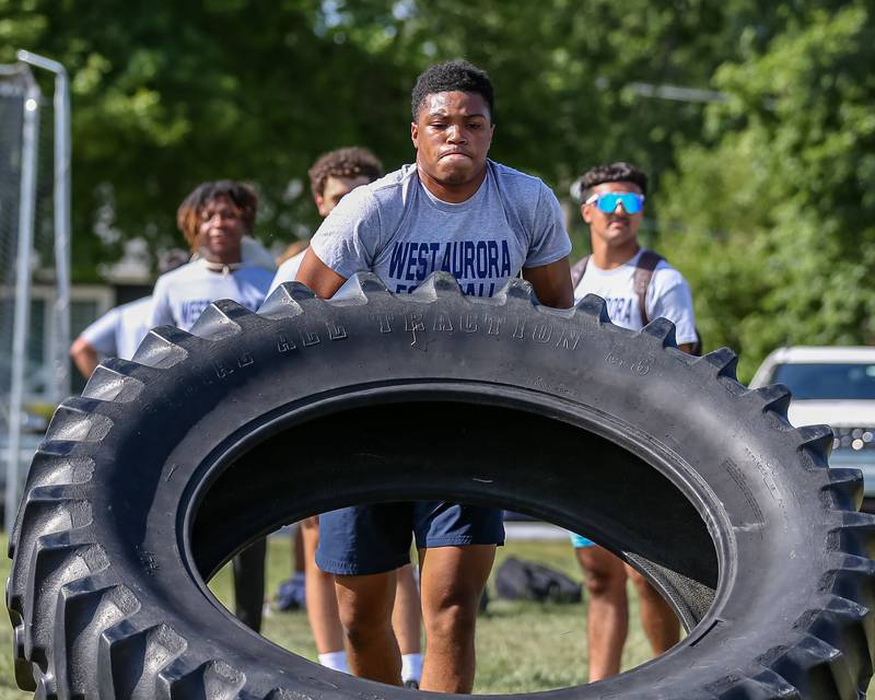 West Aurora competes in the tire flip at the West Aurora High School Battle of the Big Butts Linemen Challenge.  July 14, 2022.