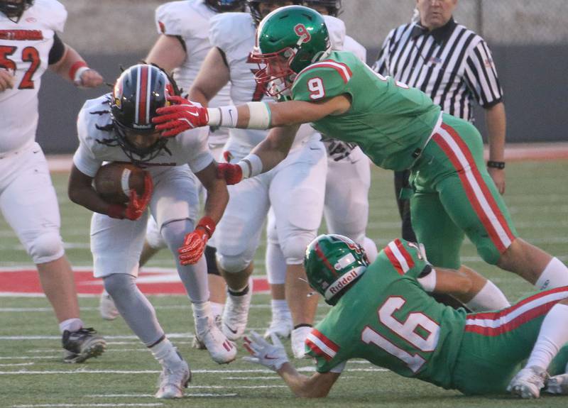 Metamora's Jaiduan Cranford runs the ball as L-P's Jaron Morscheiser looks to make the tackle as his teammate Evan Downey falls to the turf on Friday, Sept. 5, 2025 at Howard Fellows Stadium.