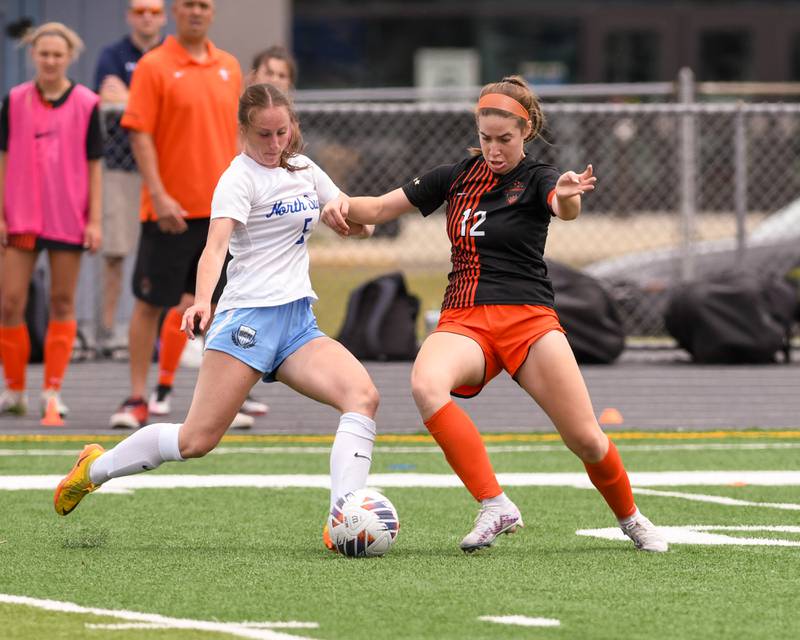 St. Charles North Rian Spaulding (5) and St. Charles East Amanda Stepien (12) battle for the ball in the first half of the sectional title game on Saturday May 27th held at West Chicago Community High School.