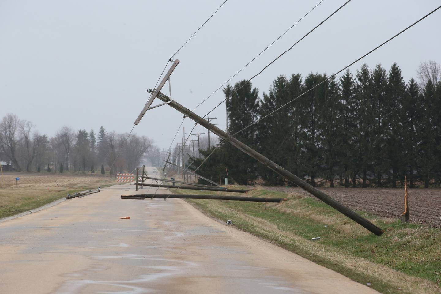 Power poles lay on the roadway along 1st Avenue on Saturday, April 1, 2023 in Mendota.