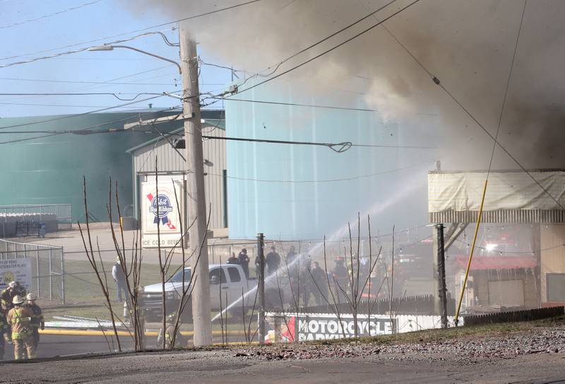 Black smoke billows from a structure fire as firefighters spray water on the front side at the former Platform 31 tavern on Monday, March 24, 2025 on Water Street in Peru. The fire was upgraded to a three-alarm summing ire departments from La Salle, Utica, Mendota, Tonica, Ottawa, Ladd, Spring Valley, Lostant, Cedar Point, Troy Grove and Peru responded to the fire.