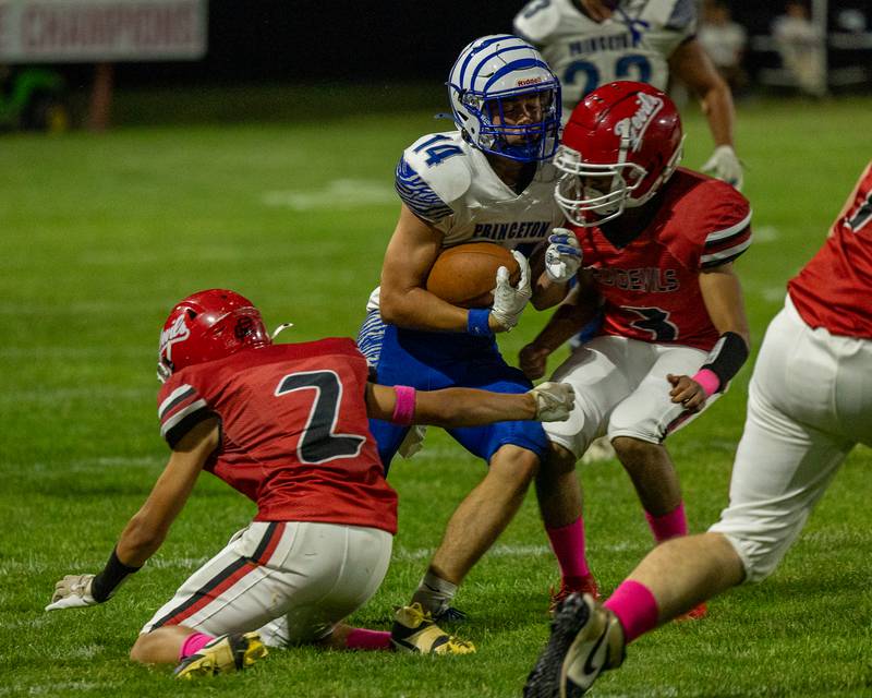Jack Oester (14) of Princeton braces for impact when running ball as (from left) Cameron Allison (2) and David Luna (3) of Hall look to tackle him on Friday, Oct. 3, 2025 at Richard Nesti Stadium in Spring Valley.