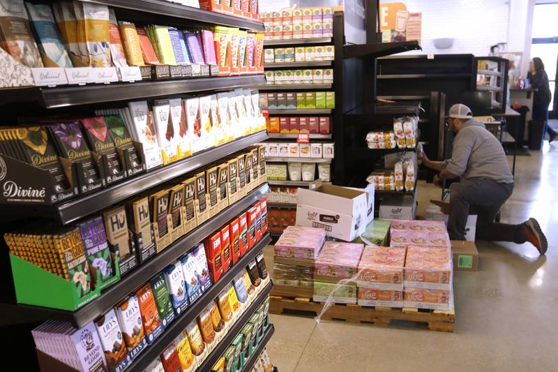 Patrick Neily with National Co+op Grocers, stocks items at the Food Shed, McHenry County's first co-op grocery store, on Friday, May 10, 2024, as the store prepares to open on May 15.