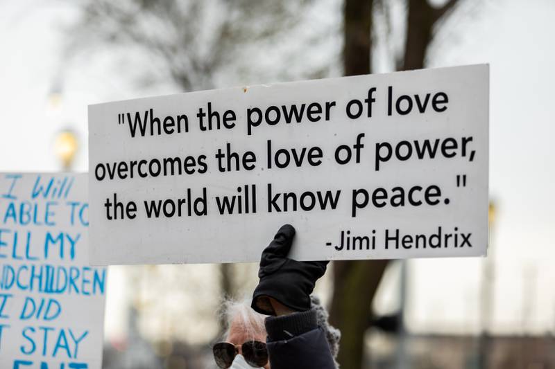 An attendee holds up a sign at the Hands Off protest in Downtown Joliet on April 5, 2025.