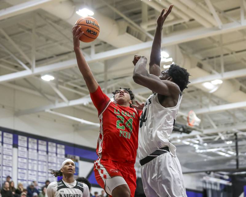 LaSalle Peru's Marion Persich (24) is defended at the basket by Kaneland's Jeffrey Hassan (34) during their Plano Christmas Classic semi-final basketball game between Kaneland at LaSalle Peru Monday, Dec 29, 2025 in Plano.