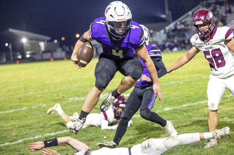 Dixon’s Landon Knigge leaps over a would be Marengo tackler Friday, Nov. 1, 2024 in the 4A football playoffs in Dixon.