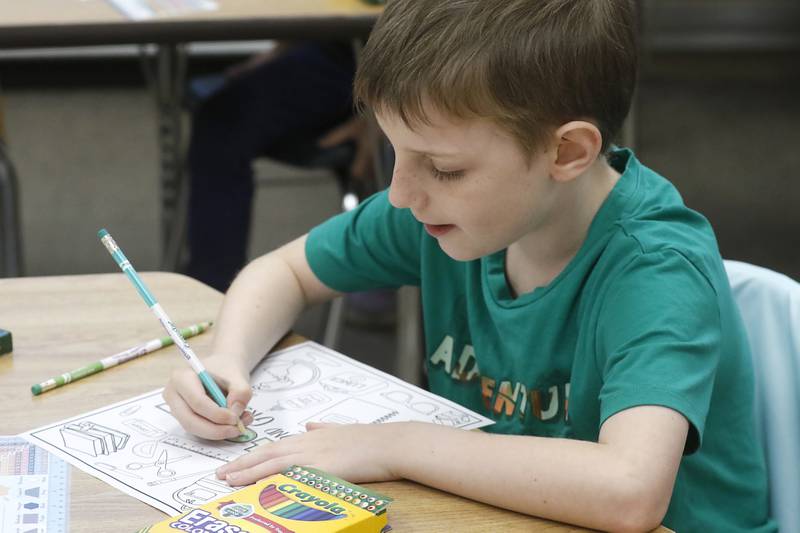 Second-grader Conner VanSiekle works on a poster about him during the first day of school for McHenry's Landmark Elementary School on Wednesday, July 17, 2024.