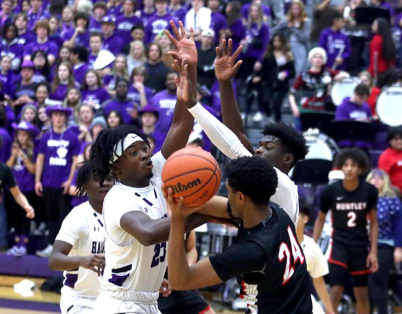 Huntley’s Noah Only, #24, looks for an option as he is double teamed by Hampshire’s Aman Adeshina, left, and Jeffrey Cruickshank in boys basketball at Hampshire on Friday.