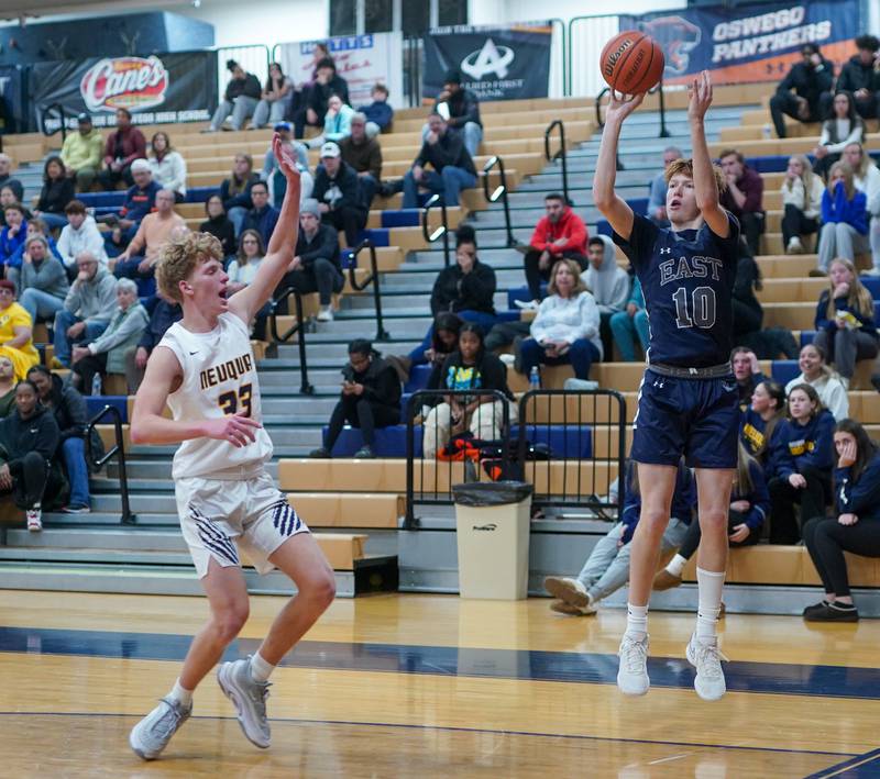 Oswego East's Noah Mason (10) shoots a three pointer from the corner against Neuqua Valley's Joe Balgro (33) during a hoops for healing basketball tournament game at Oswego High School on Friday, Nov 24, 2023.