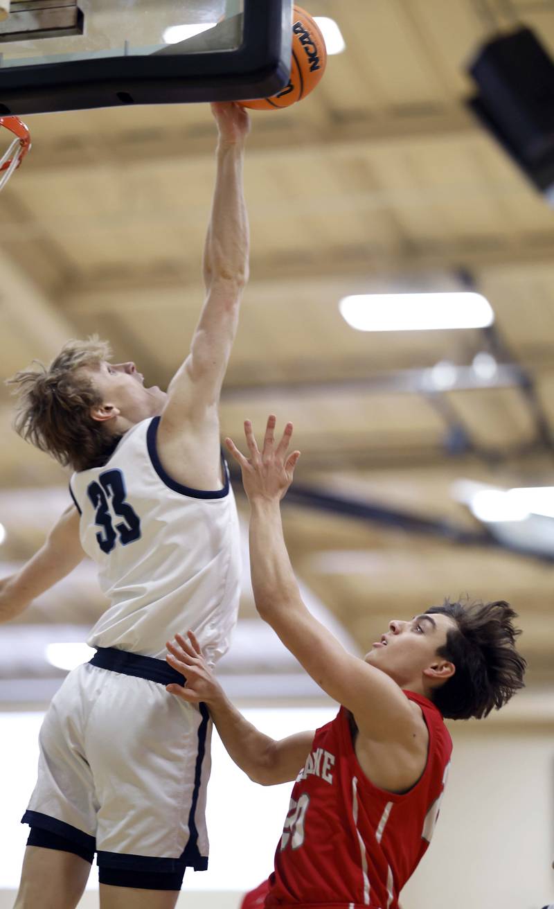 Downers Grove South’s Erik Vagonis (33) blocks a shot by Palatine’s Andy Iliopoulos (20) during the Jack Tosh Holiday Tournament Thursday, Dec. 26, 2024 at York High School in Elmhurst.