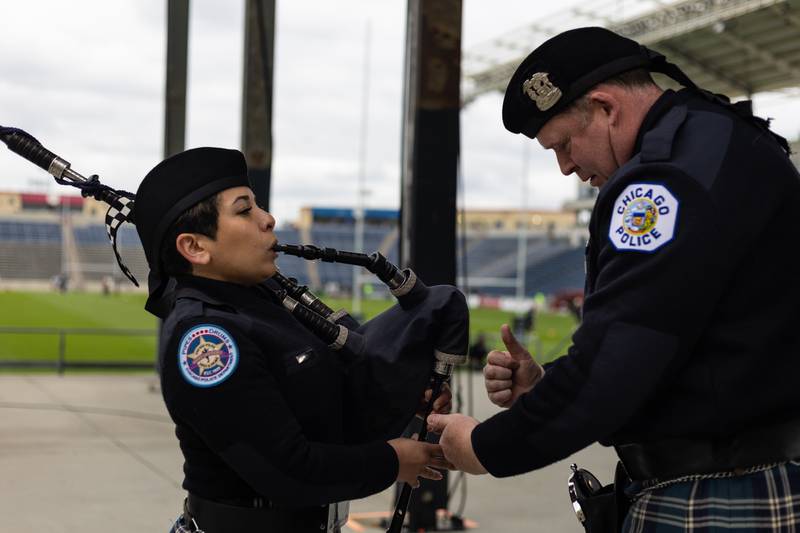 Tim Morgan, right helps Esli Kilponen, make sure her bag pipes are in tune before the lead the Chicago Hounds Rugby Club out onto the field at Seat Geek Stadium in Bridgeview, on Sunday April 23, 2023.