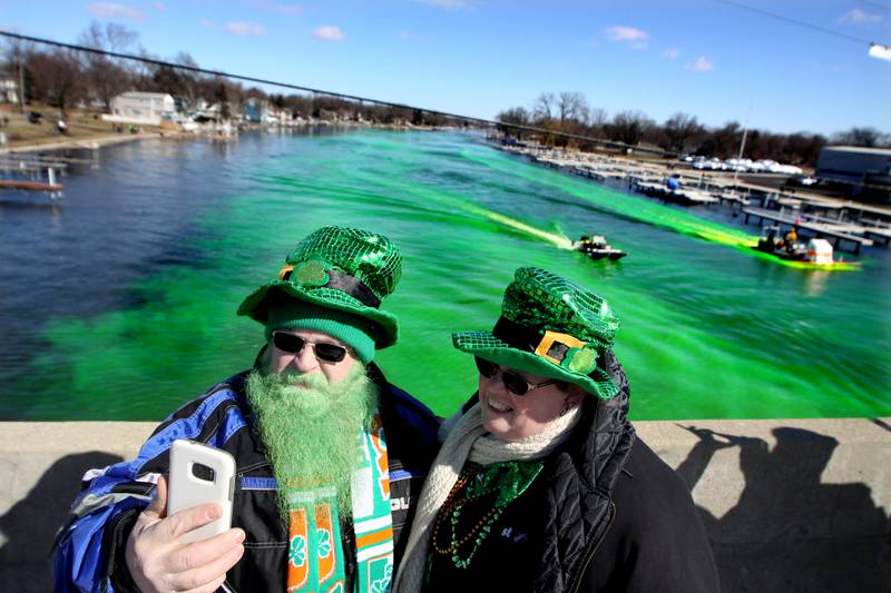 Andy and Debbie Labbe of Wonder Lake take a selfie on the Pearl Street bridge as crews work to turn the Fox River green for the ShamROCKS the Fox festival in McHenry on Saturday.