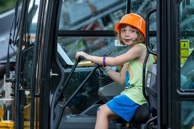 Mika Chapin sits inside a tractor at the Touch a Truck event on Sunday, July 27, 2025, at Riverfront Park in Ottawa.