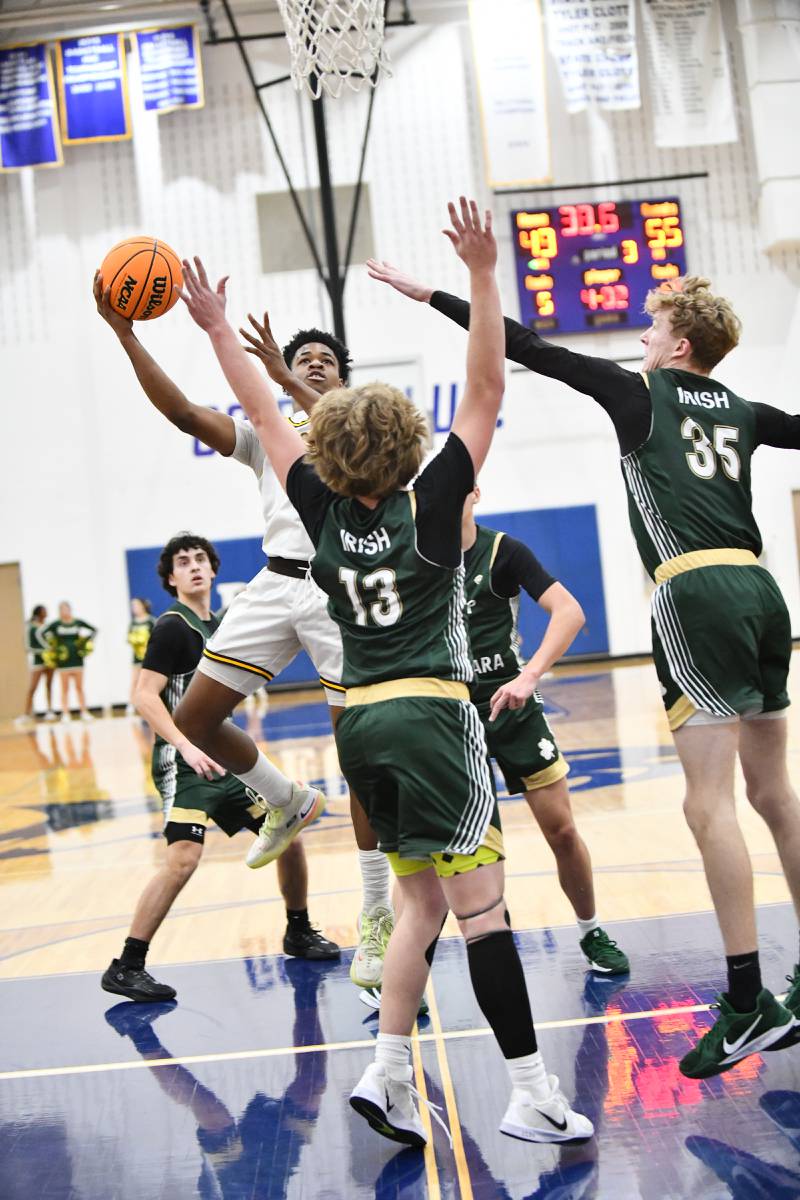 Joliet Catholic Academy's Jayden Armstrong looks to shoot under pressure from Bishop McNamara defenders during the Fightin' Irish's 79-67 victory over the Hilltoppers in the IHSA Class 2A Peotone Sectional semifinal on March 4, 2025.
