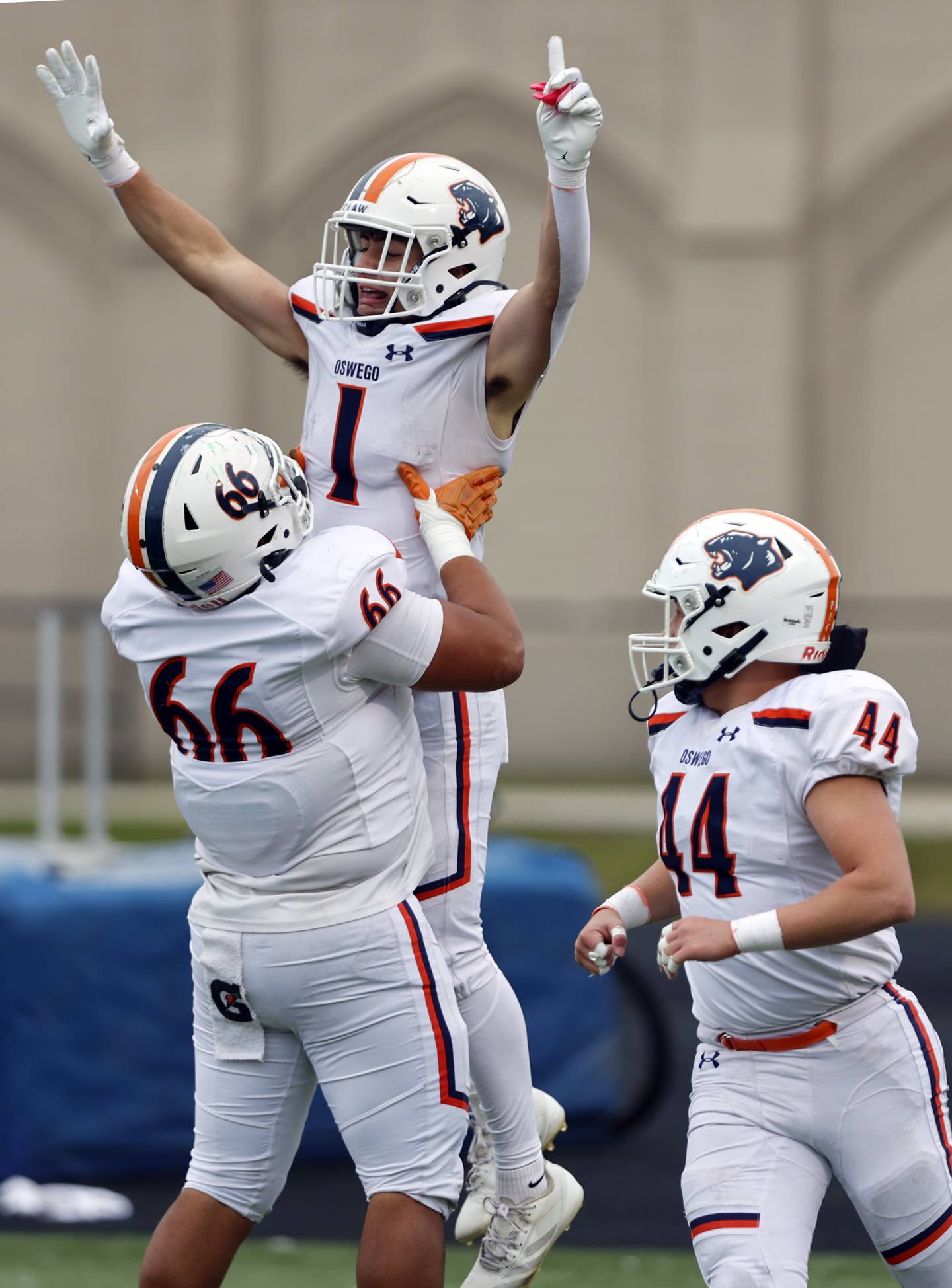 Oswego's Teddy Manikas (1) is lifted up in celebration by Khristopher Villalbazo (66) after scoring during the varsity football second-round 8A playoff game between Oswego and Lane Tech on Saturday, Nov. 8, 2025 in Chicago.