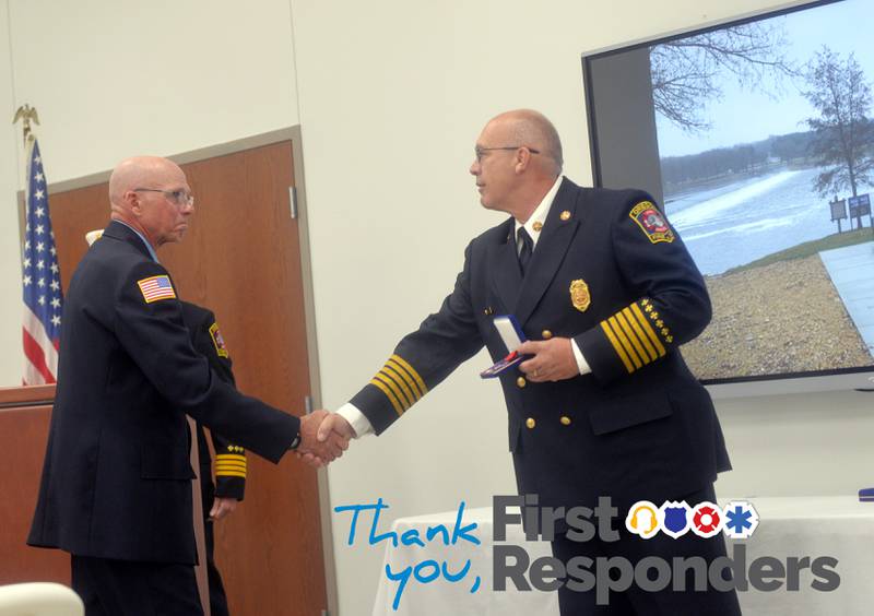 Oregon Fire Chief Mike Knoup presents Greg Hunter (left) with a Medal of Valor for his efforts in saving a woman from the Rock River in December 2022.