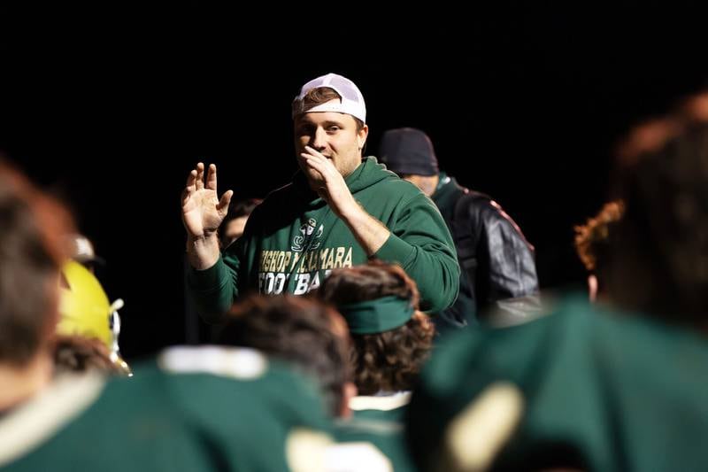 : Former Bishop McNamara head football coach Bob Kelly speaks to the Fightin' Irish after a 2023 home game against Chicago Christian. Kelly announced his resignation as football coach and dean of students Tuesday, both effective immediately.