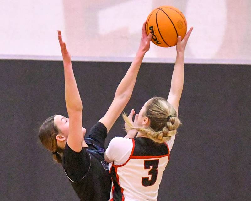 Oswego East's Aubrey Lamberti (1) blocks the shot of Yorkville's Alayna Demas (3) during the game on Thursday Dec. 18, 2025, held at Yorkville High School.