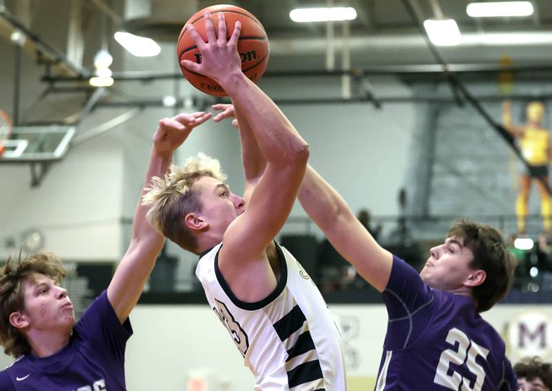 Sycamore's Carter York goes to the basket between two Rochelle defenders during their game Tuesday, Dec. 5, 2023, at Sycamore High School.