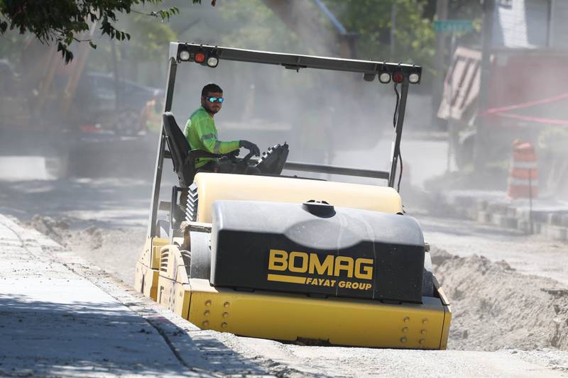 A construction worker flattens a section of Harwood Avenue between Cass Street and Sterling Avenue for repaving. Saturday, Sept. 3, 2022, in Joliet.
