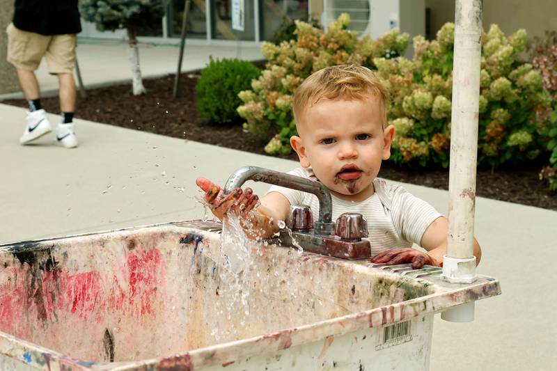 Asher Bereckis, 2, had as much fun cleaning up as he had painting Saturday, Sept. 20, 2025, in Morrison for the annual Paint the Town event.