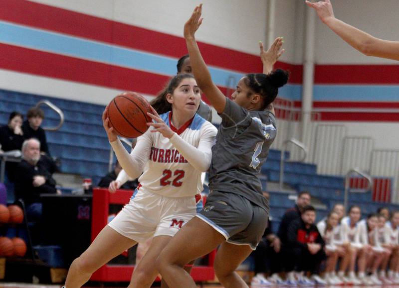 Marian Central’s Ella Notaro, left, looks for an option against Rockford Guilford in varsity girls basketball Saturday at Landers Pavilion on the campus of Marian Central High School in Woodstock.