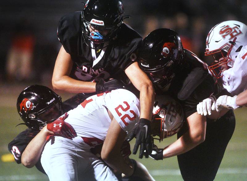 The Glenbard East defense wrap up South Elgin's Derek Thavisay (22) on. a running play during Friday’s football game in Lombard.