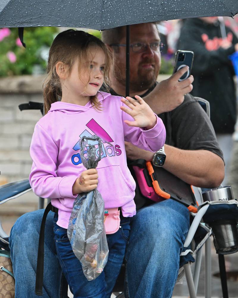 Kinsley Schaffer (5) with her father Brandon Schaffer seen watching the Crystal Lake Central H.S. 100 year homecoming day parade in downtown Crystal Lake on Saturday, Sep. 16, 2023 in Crystal Lake. The parade began at the high school and made its way through downtown Crystal Lake.