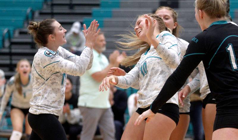 Woodstock North’s Danielle Hansen, center, and the Thunder celebrate a point t against Richmond-Burton in varsity volleyball at Woodstock Monday night.