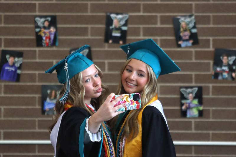 Devynn Schulze, left, and Sydney Wiegel pose for pictures before graduation at Woodstock North High School in Woodstock on Saturday, May 17, 2025.