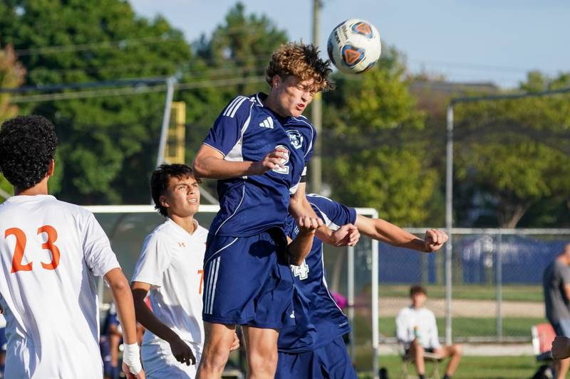 Oswego East's Cade Cummings (2) goes up for a header against Oswego during a Southwest Prairie Conference game at Oswego East High School on Thursday, Sept. 25, 2025.