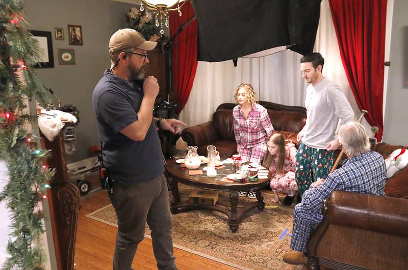 Assistant director Josh Schilling moves the actors as they set up a scene for the “Exes of Christmas Past,” while filming on Friday April 25, 2025, at the Cherry Tree Inn in Woodstock.