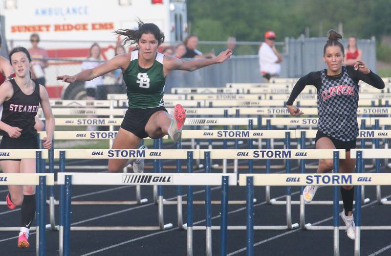 St. Bede's Lili Bosnich (center) pulls ahead of Fulton's Emery Wherry and Amboy's Elly Jones to win the 100 meter hurdles during the Class 1A Sectional meet on Wednesday, May 8, 2024 at Bureau Valley High School.