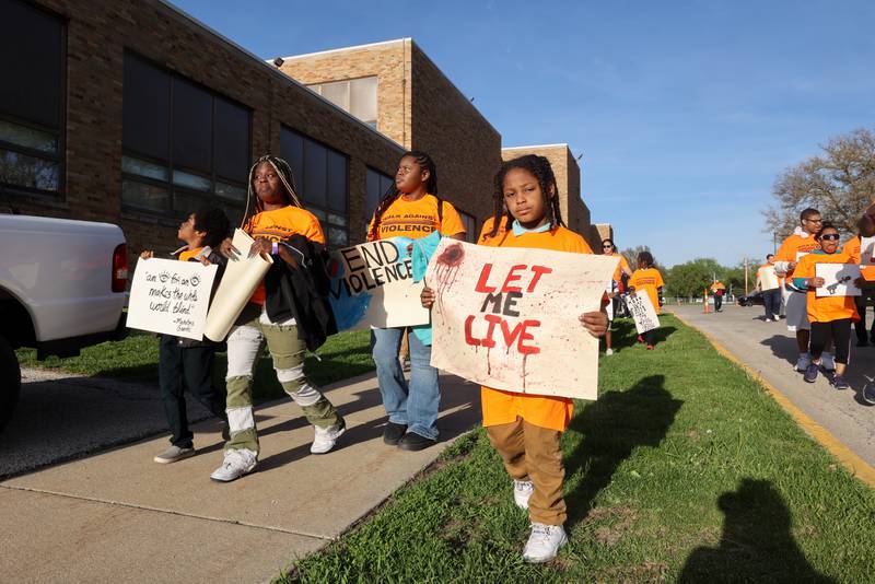 A young participants carries a sign opposing gun violence as a group of approximately 100 people begin the 2nd Walk Against Gun Violence in Kankakee on Tuesday, April 29, 2025.
