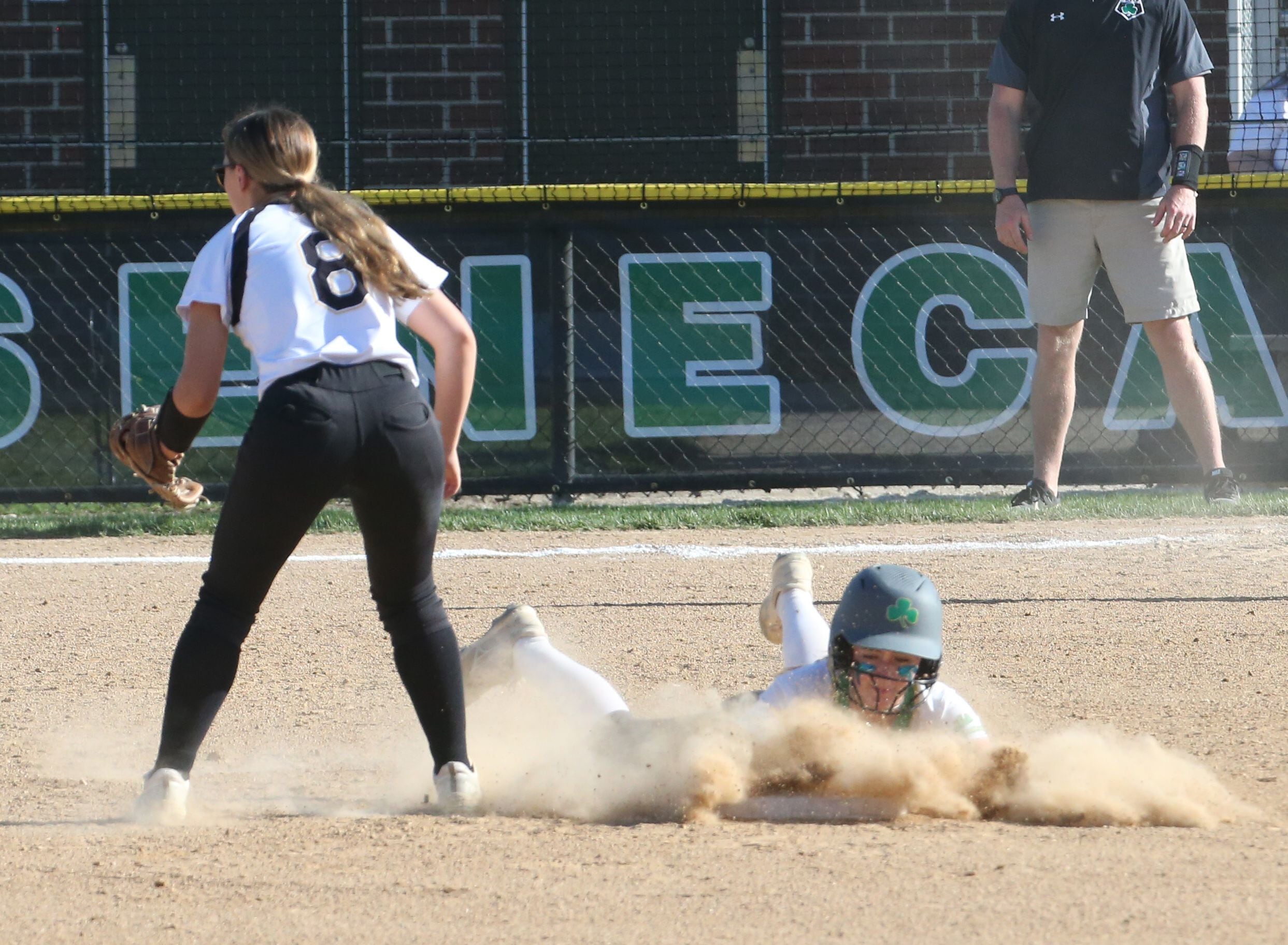 Seneca's Alyssa Zellers slides in safely to second base as Putnam County's Gabby Doyle waits for the throw.