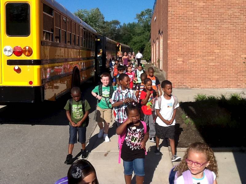 Students get off the bus for their first day of class on Wednesday at Spaulding Elementary School in Gurnee.