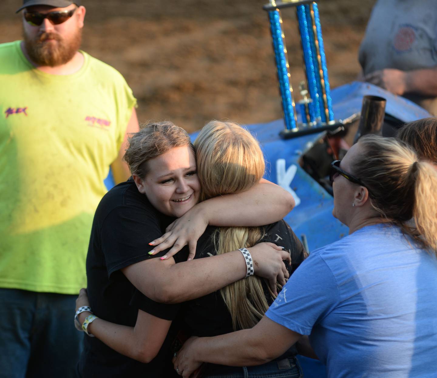 Abby Boss, 17, of Rock Falls, (left) gives her little sister Aubree, 12, a big hug after they both drove in the Young Guns heat at the Ogle County Fair's demolition derby on Saturday, Aug. 2, 2025, in Oregon.