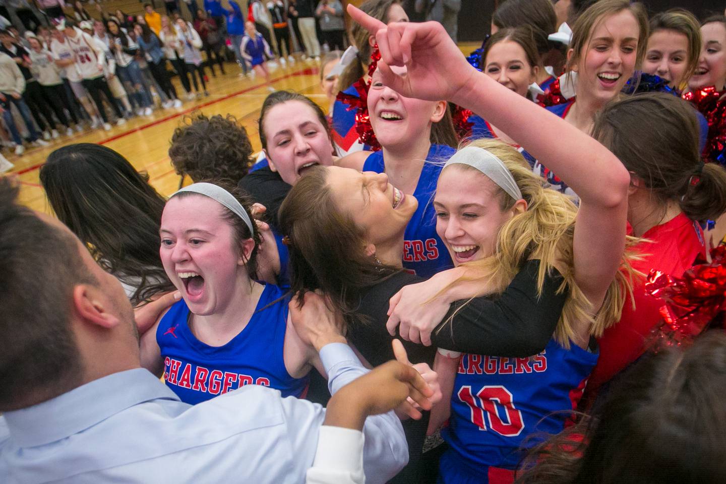 Dundee-Crown's Payton Schmidt (second from left) celebrates with assistant coach James Lopez as head coach Sarah Miller hugs Katelyn Skibinski (10) and Cassidy Randl (15) as they celebrate winning the IHSA Class 4A Huntley Sectional championship against Barrington at Huntley High School on Thursday, Feb. 27, 2020, in Huntley, Ill. Dundee-Crown won, 43-37.