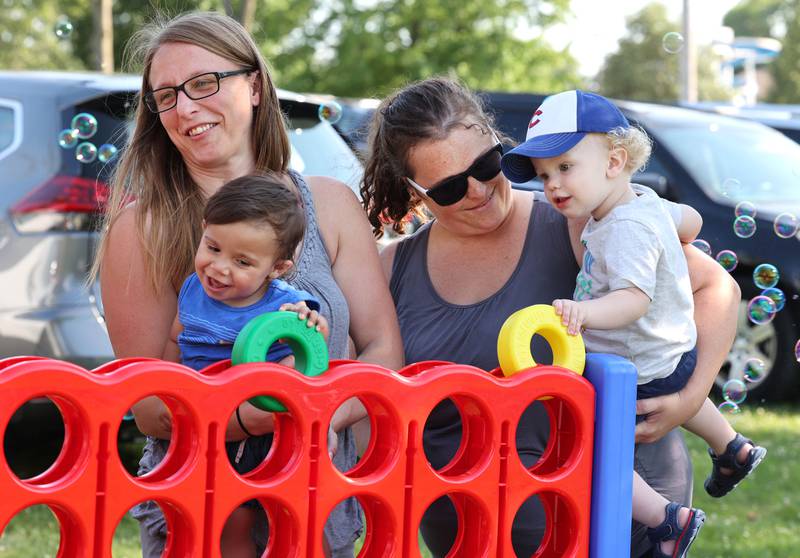 A group plays a game at the Family Service Agency booth during the Family Fun Fest Thursday, July 20, 2023, at Hopkins Park in DeKalb.